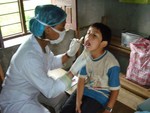 Dr. Rabina checking teeth of 8 yrs student