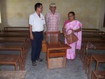 staff installing special chair in a classroom